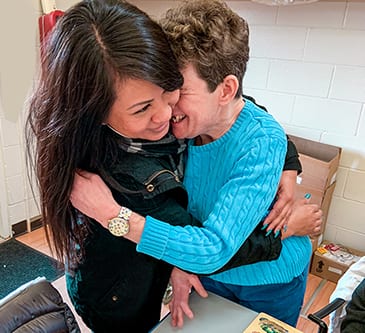 Special needs adult hugging teacher at Bay Area School